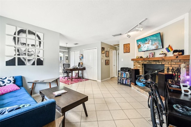 1239 E Ridgewood St, Orlando, FL 32803 - living area with light tile patterned flooring, track lighting, a fireplace, baseboards, and visible vents
