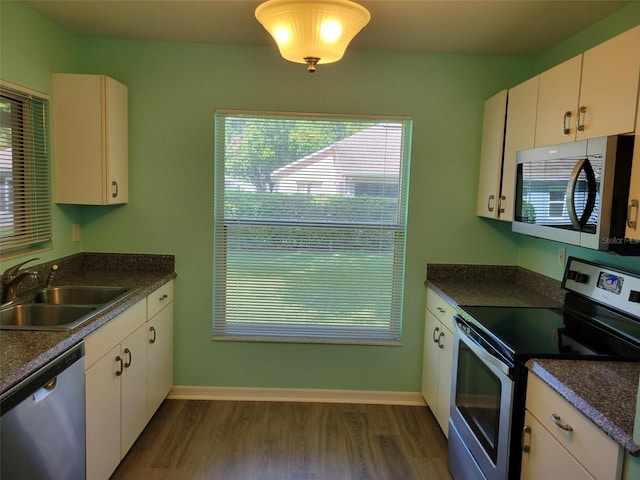 3586 Eversholt St, Clermont, FL 34711 - kitchen with appliances with stainless steel finishes, a sink, dark wood-style flooring, dark countertops, and healthy amount of natural light