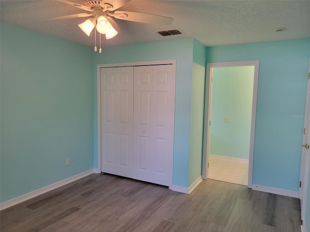 3586 Eversholt St, Clermont, FL 34711 - unfurnished bedroom featuring wood finished floors, a closet, a textured ceiling, baseboards, and a ceiling fan