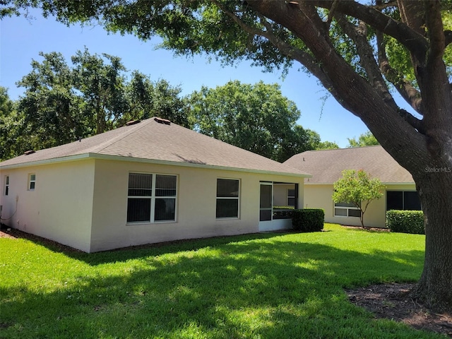 3586 Eversholt St, Clermont, FL 34711 - back of house featuring a yard, stucco siding, and a shingled roof