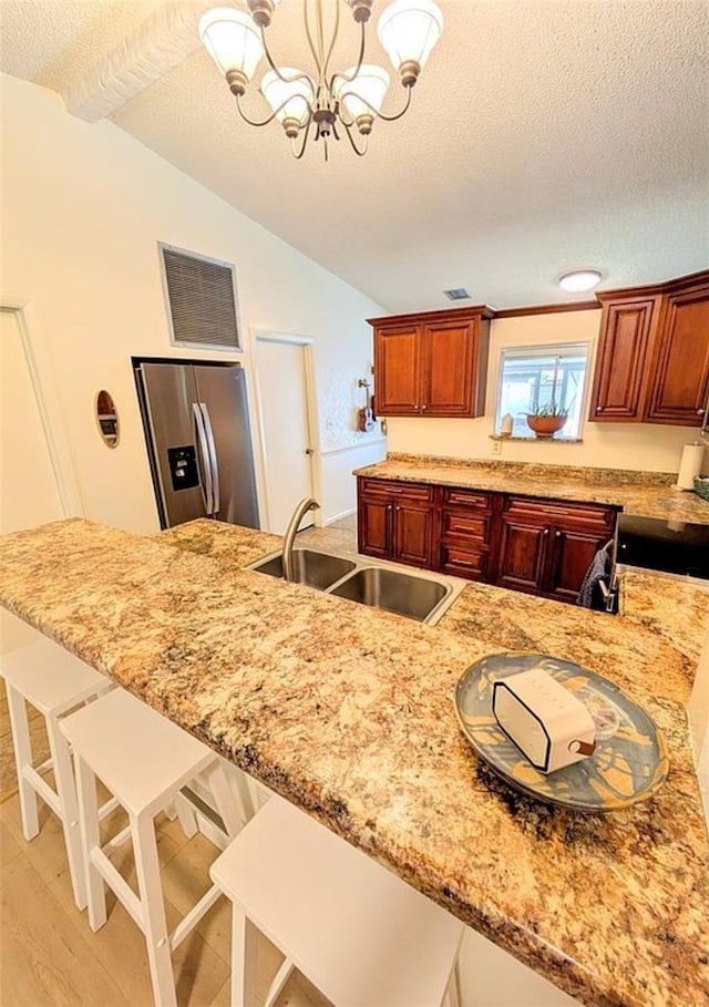 600 Lake St, Fruitland Park, FL 34731 - kitchen featuring a breakfast bar, stainless steel fridge with ice dispenser, a sink, visible vents, and a textured ceiling