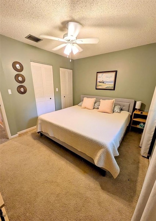 600 Lake St, Fruitland Park, FL 34731 - carpeted bedroom with a textured ceiling, ceiling fan, visible vents, baseboards, and multiple closets