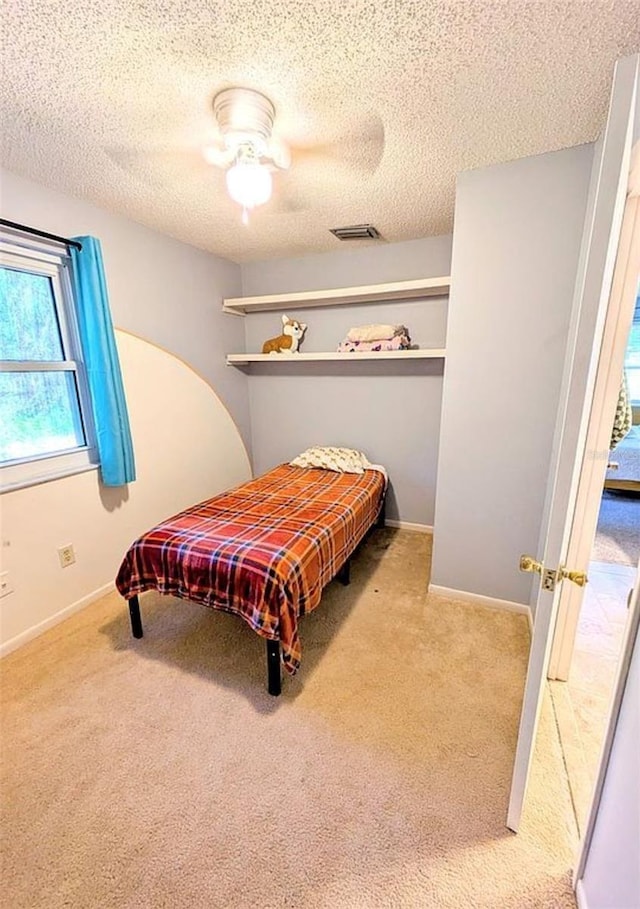 600 Lake St, Fruitland Park, FL 34731 - carpeted bedroom with a textured ceiling, visible vents, ceiling fan, and baseboards