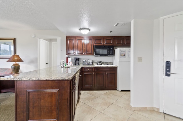 6402 Parc Corniche Dr # 5304, Orlando, FL 32821 - kitchen featuring a textured ceiling, white appliances, light tile patterned floors, a peninsula, and light stone countertops