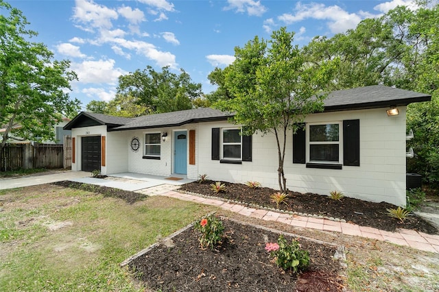 single story home with fence, concrete driveway, a shingled roof, and a garage