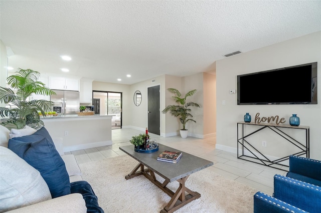 living area with a textured ceiling, visible vents, and recessed lighting