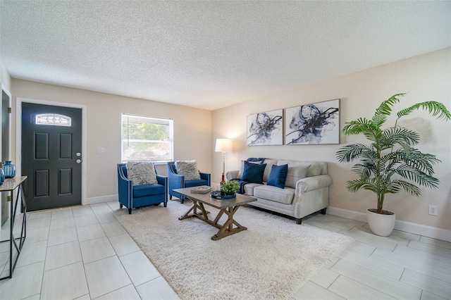 living room with a textured ceiling and baseboards