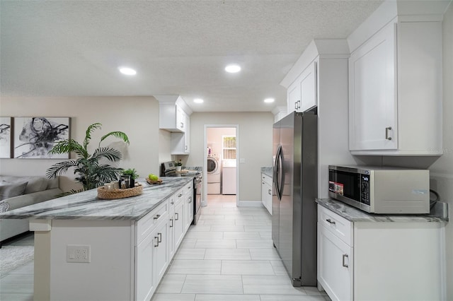 kitchen featuring appliances with stainless steel finishes, recessed lighting, washer / clothes dryer, and white cabinets