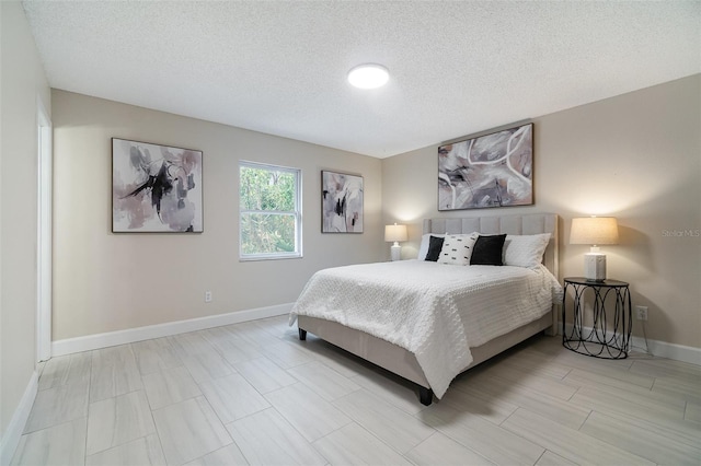 bedroom featuring a textured ceiling and baseboards