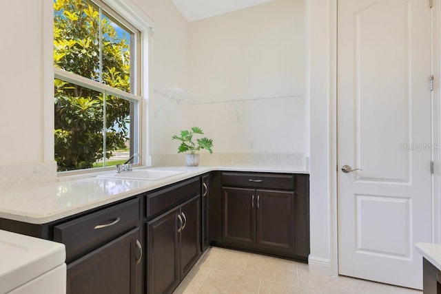 bar featuring a sink, plenty of natural light, and light tile patterned flooring