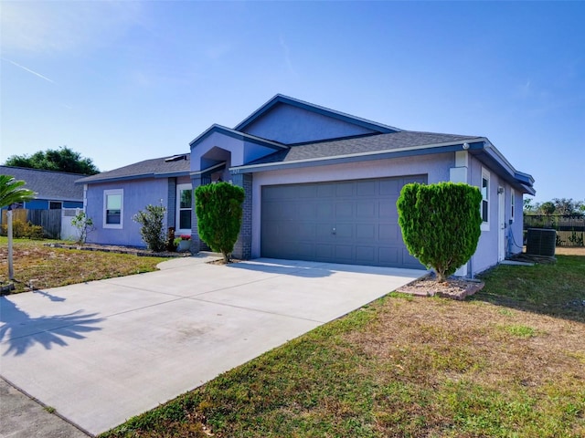 single story home featuring a front lawn, stucco siding, driveway, and an attached garage