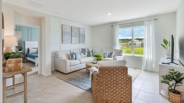 living room featuring baseboards, visible vents, light tile patterned floors, and recessed lighting