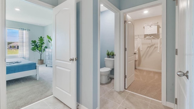 full bath featuring baseboards, recessed lighting, tile patterned floors, toilet, and a walk in closet