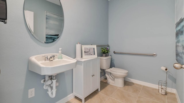 bathroom with toilet, tile patterned floors, and baseboards