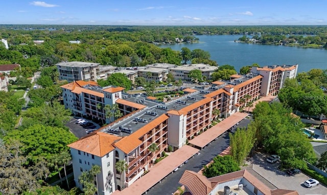 birds eye view of property with a water view and a wooded view