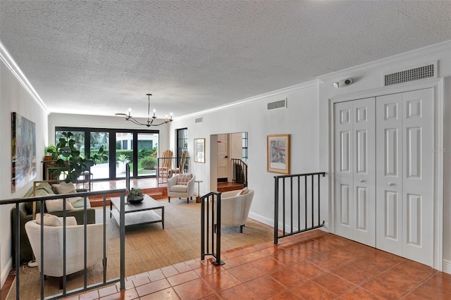 living area with visible vents, ornamental molding, and an inviting chandelier
