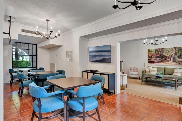 tiled dining room featuring an inviting chandelier, ornamental molding, a textured ceiling, and visible vents