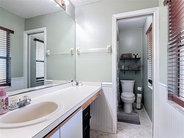 1021 Whalebone Bay Dr, Kissimmee, FL 34741 - bathroom with toilet, a wainscoted wall, a textured ceiling, and vanity