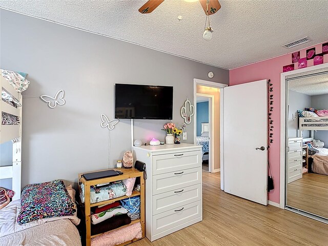 1021 Whalebone Bay Dr, Kissimmee, FL 34741 - bedroom with a textured ceiling, visible vents, a ceiling fan, and light wood-style floors