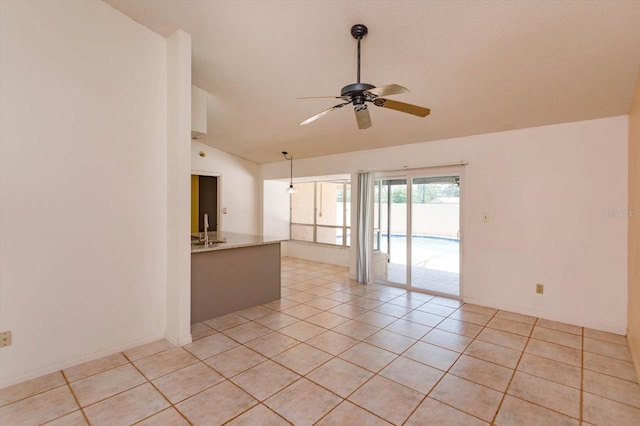empty room with light tile patterned floors, a ceiling fan, and lofted ceiling