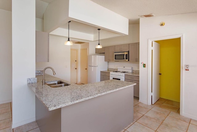 kitchen featuring a sink, visible vents, light stone countertops, white appliances, and a peninsula