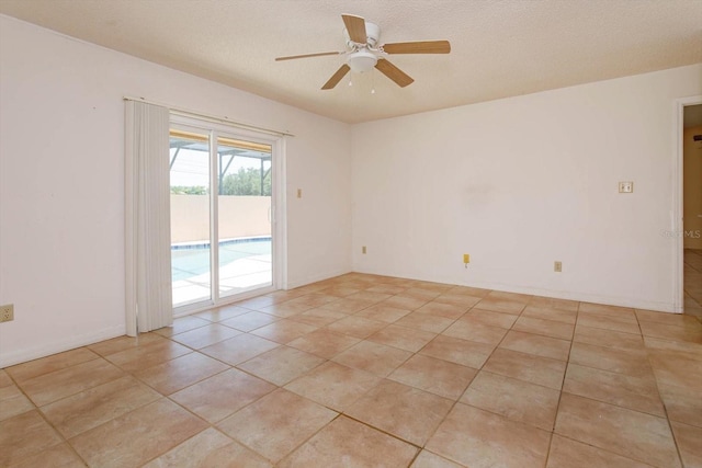 empty room featuring light tile patterned floors, a textured ceiling, and ceiling fan