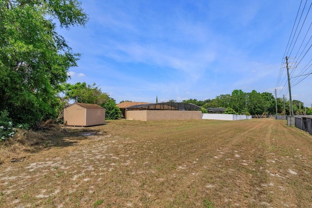 view of yard featuring fence, a shed, and an outbuilding