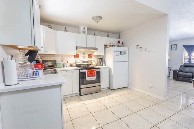 349 Caldbeck Way, Kissimmee, FL 34758 - kitchen featuring stainless steel electric range oven, light countertops, freestanding refrigerator, white cabinetry, and under cabinet range hood