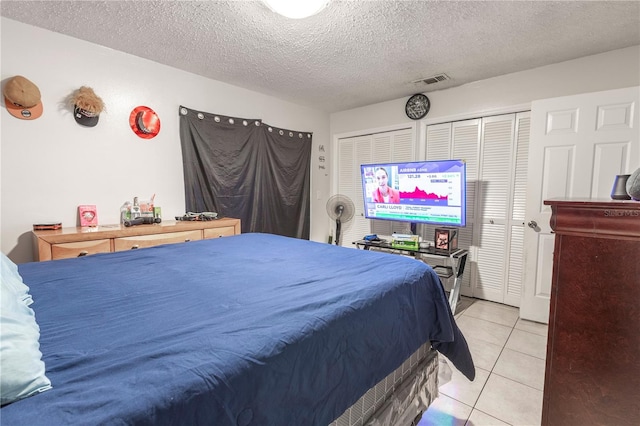 349 Caldbeck Way, Kissimmee, FL 34758 - tiled bedroom featuring two closets, a textured ceiling, and visible vents