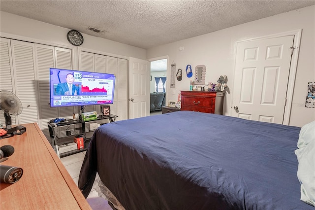 349 Caldbeck Way, Kissimmee, FL 34758 - bedroom featuring light tile patterned floors, multiple closets, a textured ceiling, and visible vents