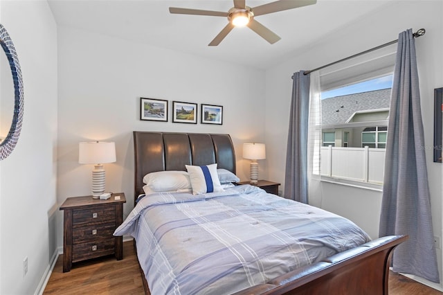 bedroom with a ceiling fan, baseboards, and wood finished floors