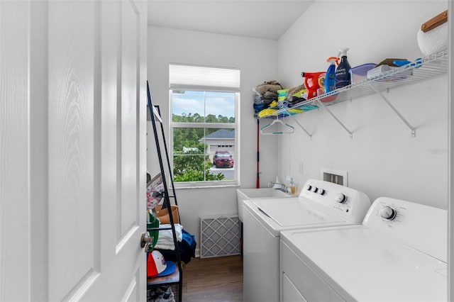 clothes washing area featuring laundry area, visible vents, wood finished floors, washer and clothes dryer, and a sink