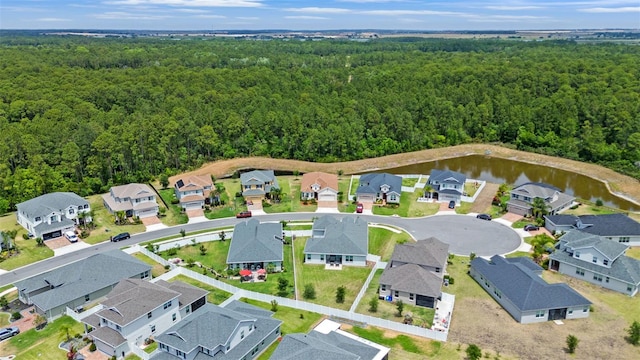 birds eye view of property with a water view, a residential view, and a wooded view
