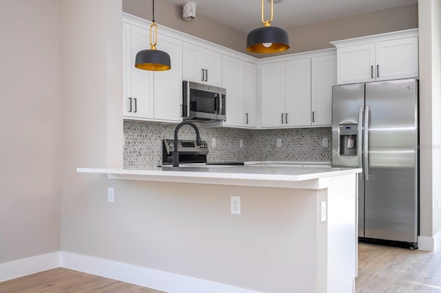 2041 Warrens Ave, Maitland, FL 32751 - kitchen with light wood-type flooring, light countertops, a peninsula, and stainless steel appliances
