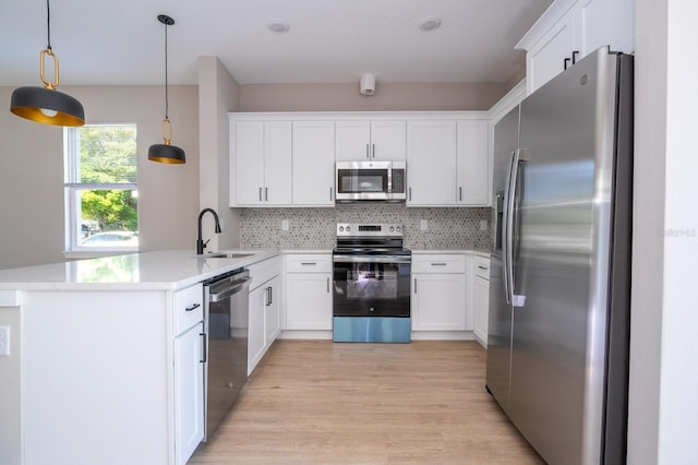 2041 Warrens Ave, Maitland, FL 32751 - kitchen featuring appliances with stainless steel finishes, a sink, light wood-style floors, a peninsula, and decorative backsplash