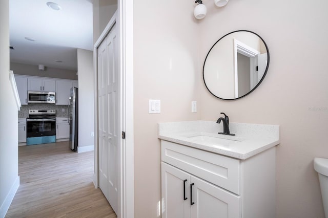 2041 Warrens Ave, Maitland, FL 32751 - bathroom with vanity, toilet, wood finished floors, and tasteful backsplash