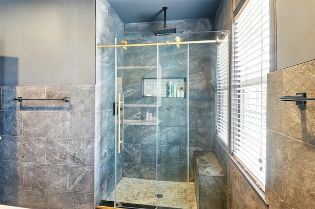 full bathroom featuring tile walls and a shower stall