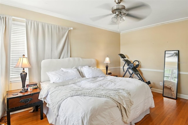 bedroom with baseboards, wood finished floors, and crown molding
