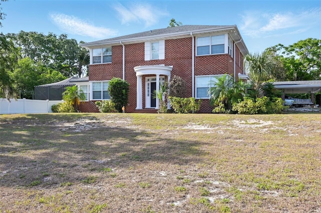 view of front facade featuring a front lawn, fence, and brick siding