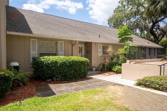 entrance to property with roof with shingles