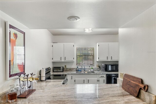 kitchen with light stone counters, a sink, white cabinetry, a toaster, and black appliances