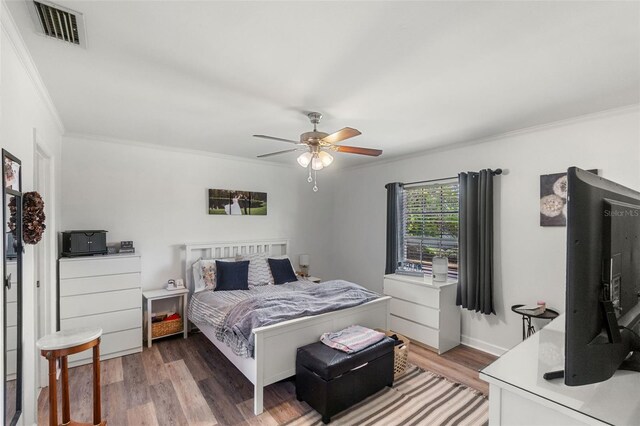 bedroom with crown molding, a ceiling fan, light wood finished floors, and visible vents