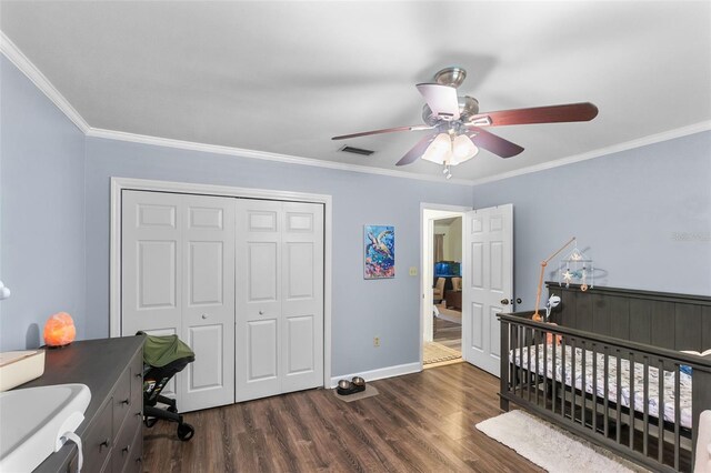 bedroom with visible vents, ornamental molding, wood finished floors, and a closet