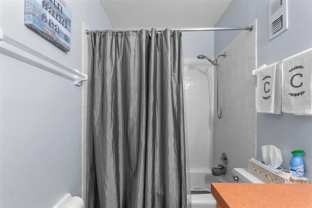 bathroom with vanity, shower / bath combo, and toilet