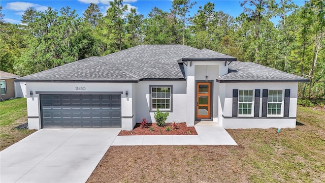 13430 SW 88th Ter, Ocala, FL 34473 - view of front of home with a garage, roof with shingles, stucco siding, and driveway