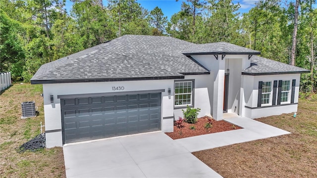 13430 SW 88th Ter, Ocala, FL 34473 - view of front of property featuring roof with shingles, a garage, stucco siding, central air condition unit, and driveway