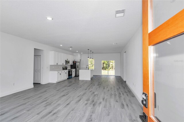 13430 SW 88th Ter, Ocala, FL 34473 - unfurnished living room featuring light wood-style floors, baseboards, and recessed lighting