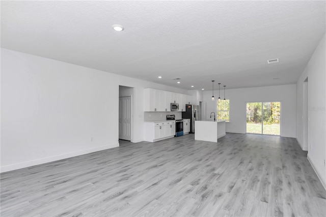 13430 SW 88th Ter, Ocala, FL 34473 - unfurnished living room featuring recessed lighting, baseboards, a sink, and light wood-style floors