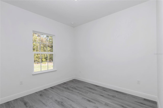 13430 SW 88th Ter, Ocala, FL 34473 - empty room with baseboards, a healthy amount of sunlight, and wood finished floors
