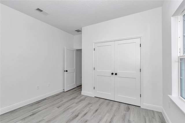 13430 SW 88th Ter, Ocala, FL 34473 - unfurnished bedroom featuring a closet, baseboards, visible vents, and light wood-style floors